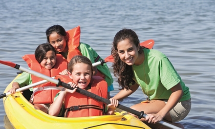 Medewerker recreatie en sport helpt kinderen met de kano