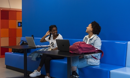 twee studenten mbo lachend achter hun laptop